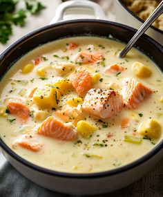 a bowl of soup with salmon and potatoes