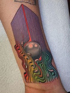 a colorful tattoo on the arm of a person with an object in the middle of it