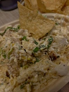 a white plate topped with chips and coleslaw next to tortilla chips