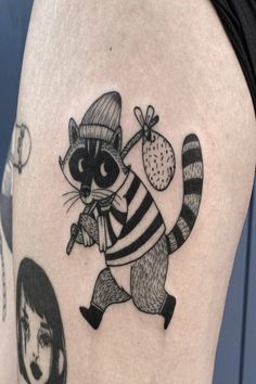 a raccoon with a hat and scarf on it's head is depicted in this tattoo design