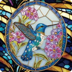 a stained glass window with a hummingbird on it's side and flowers in the background