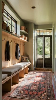 a room with a rug, coat rack and benches