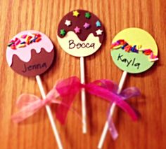 three cake pops with name on them sitting on a table