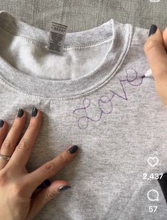 someone is doing something with their nails on top of a t - shirt that says love