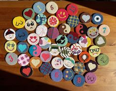 a table topped with lots of different types of felt covered buttons on top of a wooden table