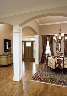 a large living room with wood flooring and chandelier