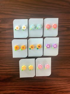 six pairs of flower studs are displayed on a table