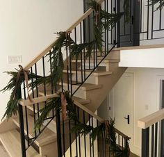 the stairs are decorated with pine cones and evergreen garlands for holiday decor on each handrail