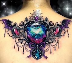 the back of a woman's neck with an intricate tattoo design on her chest