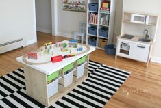 a child's playroom with toys and books on the table in front of it