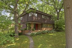 a brown house surrounded by trees and grass