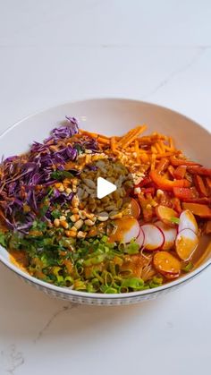 a white bowl filled with lots of different types of food on top of a table