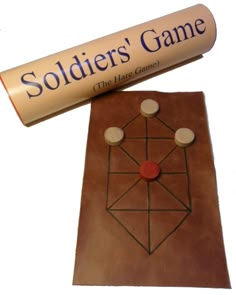 a game board with two pieces of leather and a stick that says soldier's game on it