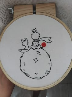 someone is holding up a cross - stitch embroidery project