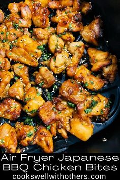 an air fryer filled with chicken bites and sesame seed sprinkled on top