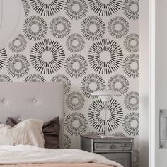 a bed sitting under a mirror next to a wall mounted clock on the side of a wall