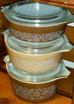 three glass casseroles stacked on top of each other in front of a wooden cabinet