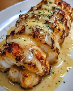 a white plate topped with chicken covered in gravy