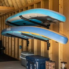 two surfboards mounted to the side of a wooden wall next to a blue cooler