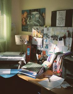 a cluttered desk in an office with many papers and pens on top of it