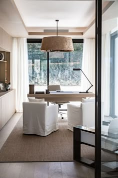 a living room filled with furniture and a lamp hanging over the top of a table