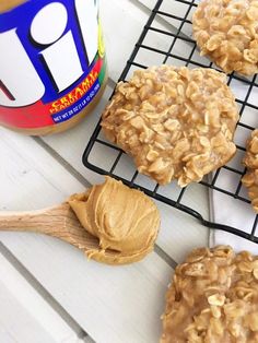 peanut butter cookies cooling on a rack next to a jar of peanut butter and spoon