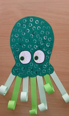 an octopus made out of toilet paper on top of a wooden table with green tape