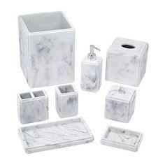 white marble bathroom accessories including soap dispenser, toothbrush holder and tissue dispenser