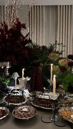 a table topped with lots of desserts and candles