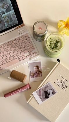 an open laptop computer sitting on top of a desk next to a jar of makeup