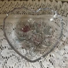 a heart shaped glass bowl sitting on top of a table