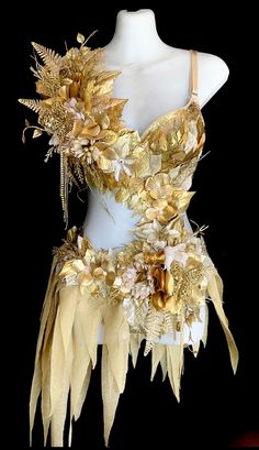 a white mannequin with gold flowers on it's chest and headpiece