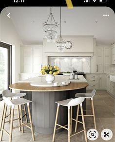 a kitchen island with stools in front of it and a chandelier hanging from the ceiling