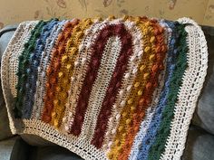 a crocheted blanket sitting on top of a couch