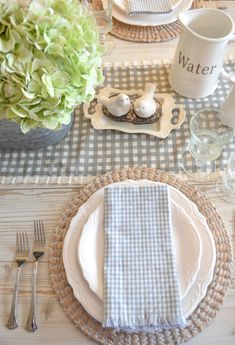 the table is set with dishes, cups and silverware