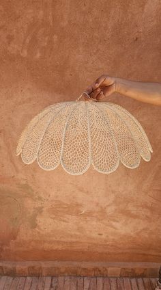 a person holding an object in their hand on the ground next to a brick wall