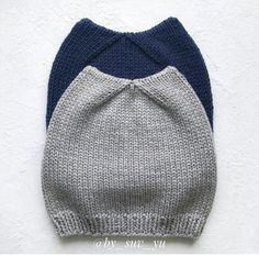 two knitted hats on top of each other against a white wall with blue and gray accents