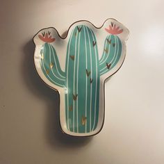 a green cactus shaped dish sitting on top of a white counter next to a wall