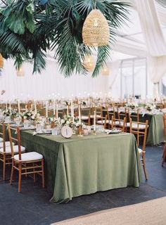 the tables are set with green linens and candles