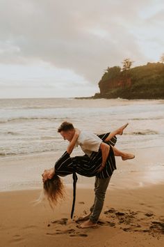 two people doing acrobatic tricks on the beach