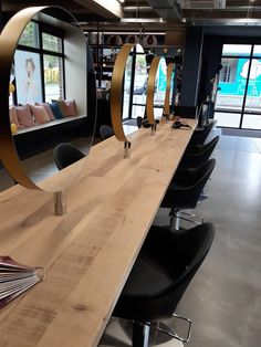 a table that has some chairs and a mirror on it in front of a window