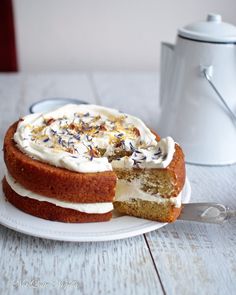 a cake with white frosting and sprinkles sitting on top of a plate