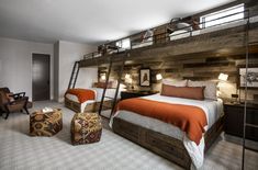 two beds in a room with wooden walls and ladders on the wall above them