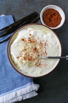 a bowl filled with whipped cream and cinnamon on top of a blue towel next to two bowls