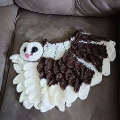 a crocheted owl rug is laying on a couch