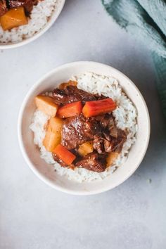 two bowls filled with rice and beef stew