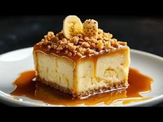 a piece of cheesecake on a white plate with caramel sauce and nuts in the middle