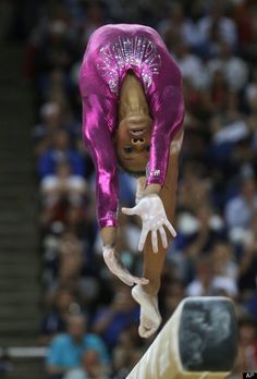 a person doing a handstand on the balance beam