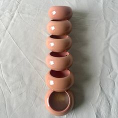 three pink vases are stacked on top of each other in front of a white background