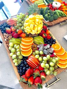 two trays filled with different types of fruits and veggies on top of each other